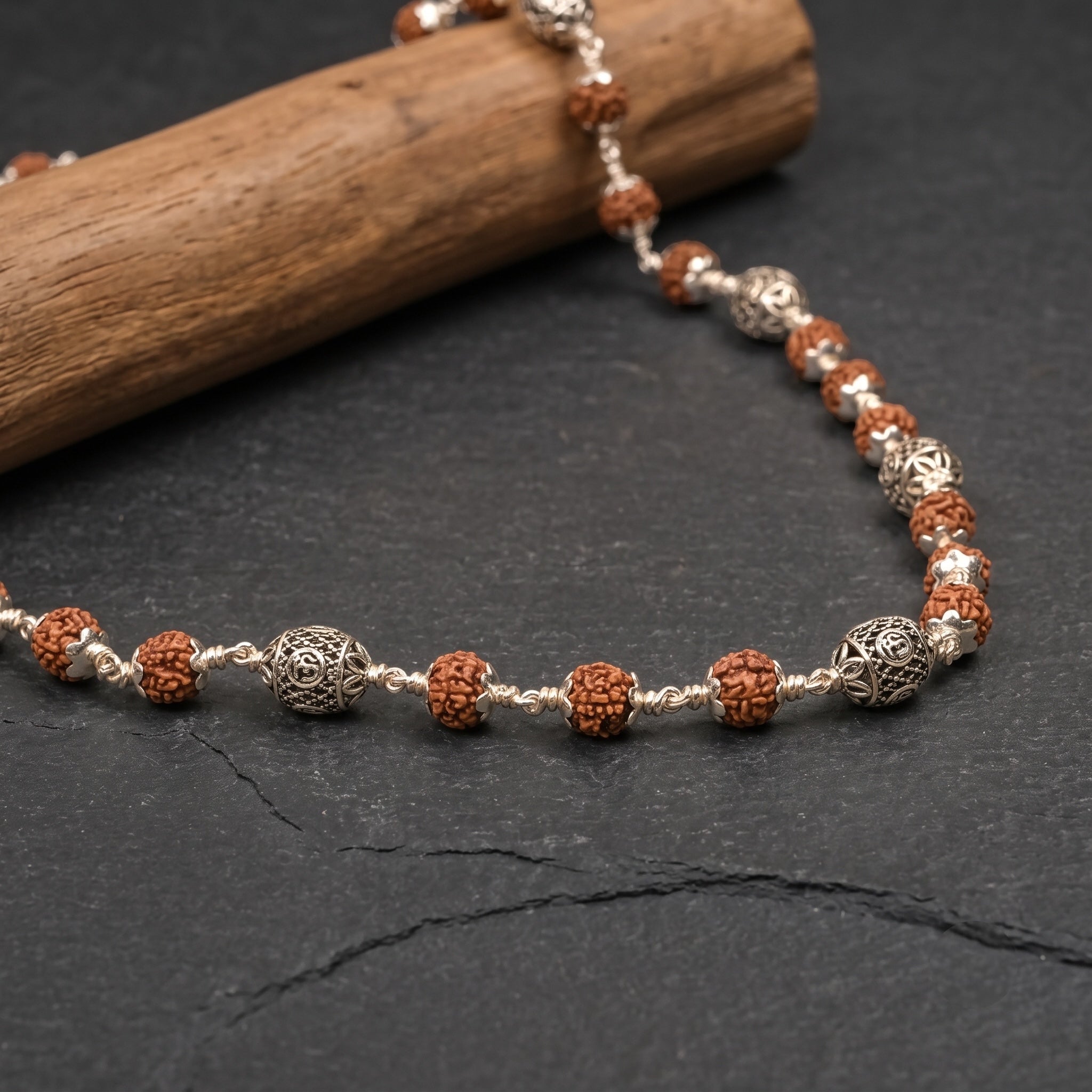 Angled Rudraksha mala showing handcrafted 925 silver Om beads