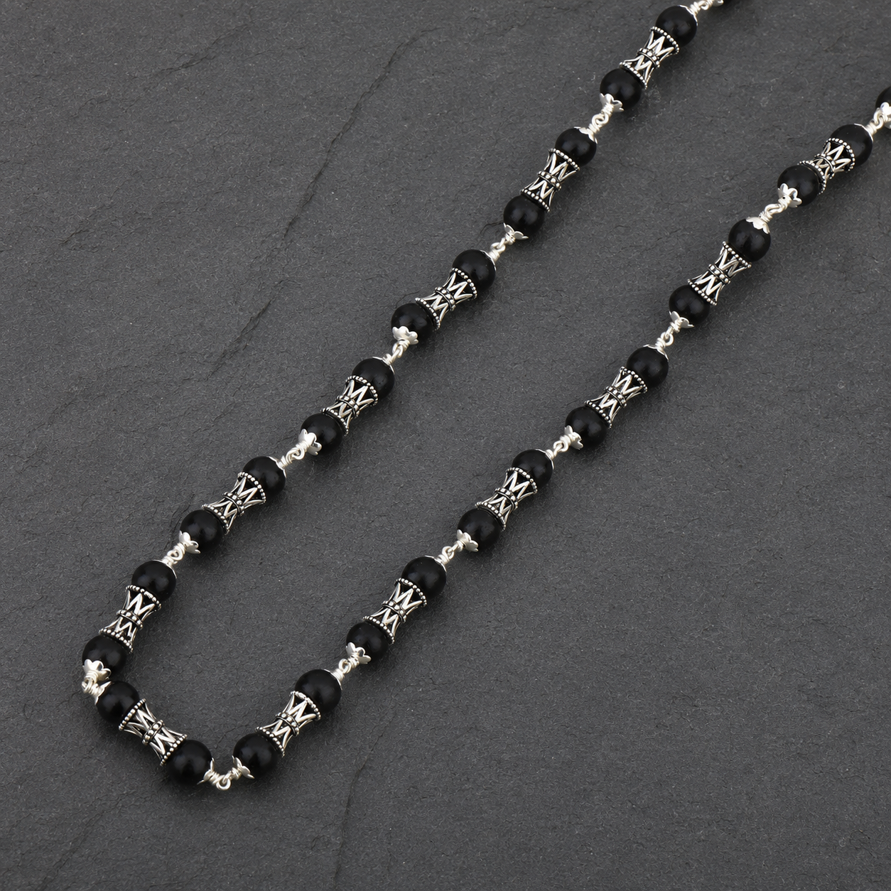 Black Karungali and silver Damru bead close-up