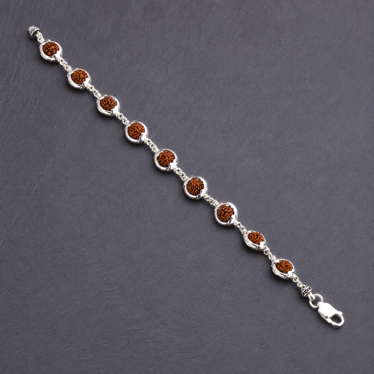 Close-up of 6–7 mm Rudraksha beads with decorative silver caps