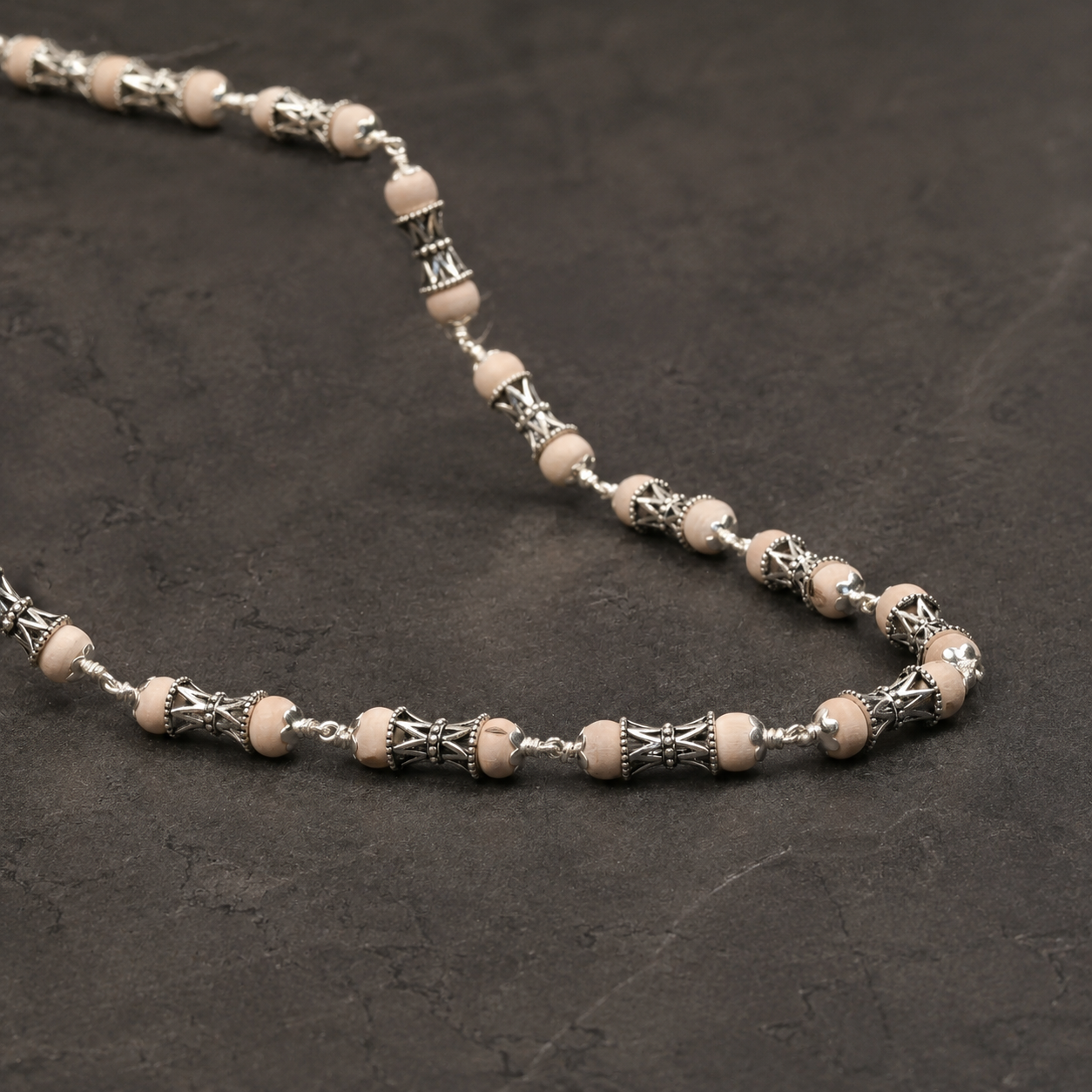 Close-up of 925 silver Damru beads on Tulsi mala