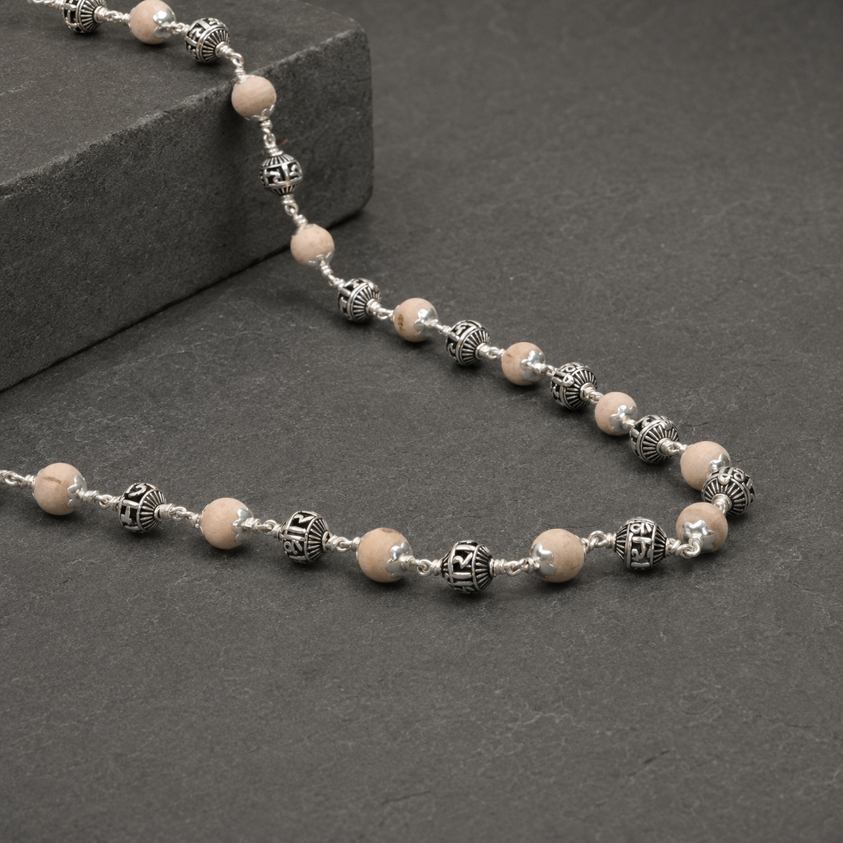 Close-up of Jay Shree Ram engraving on silver beads