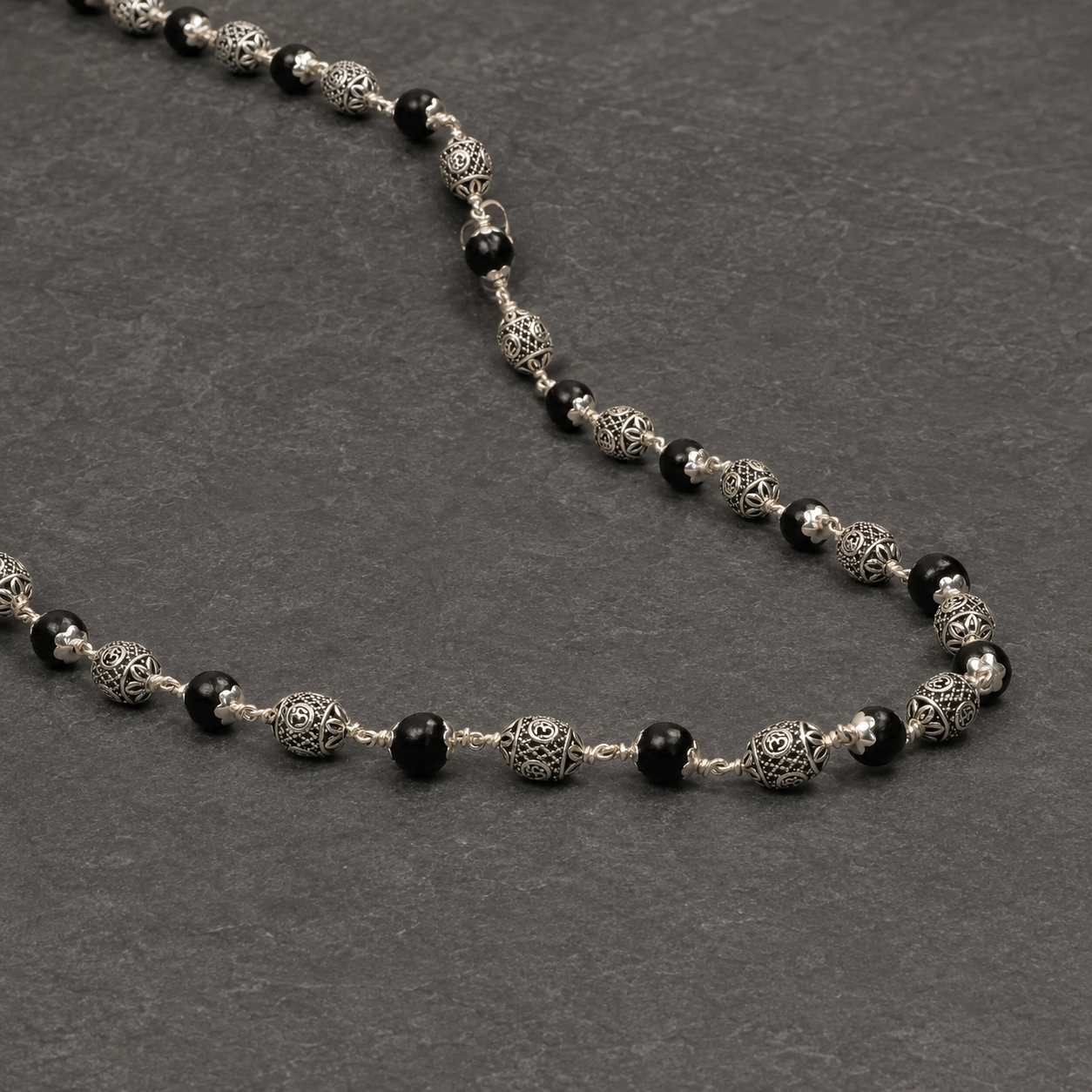 Close-up of Karungali and 925 silver Oval Om beads
