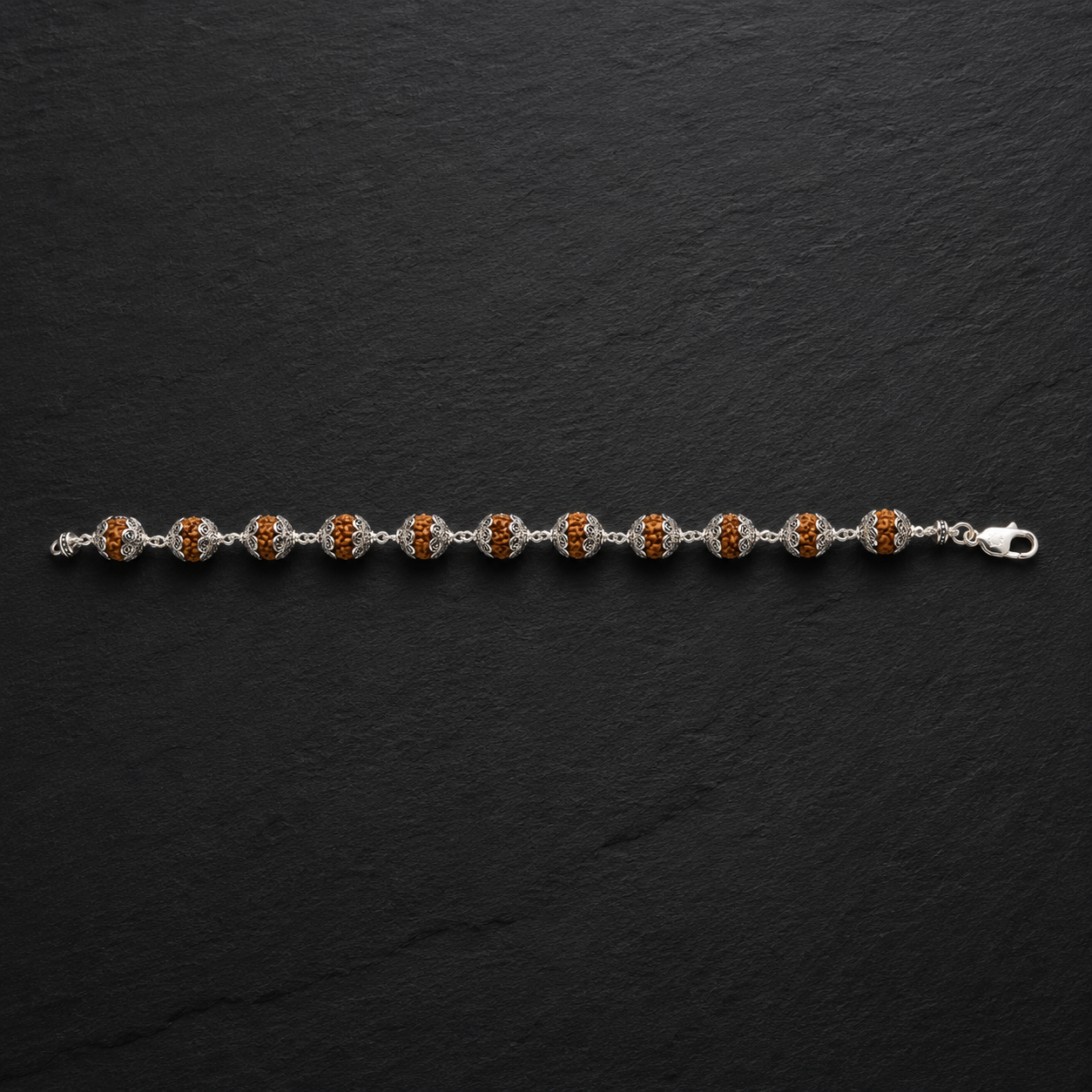 Close-up of Om sterling silver caps on Rudraksha beads