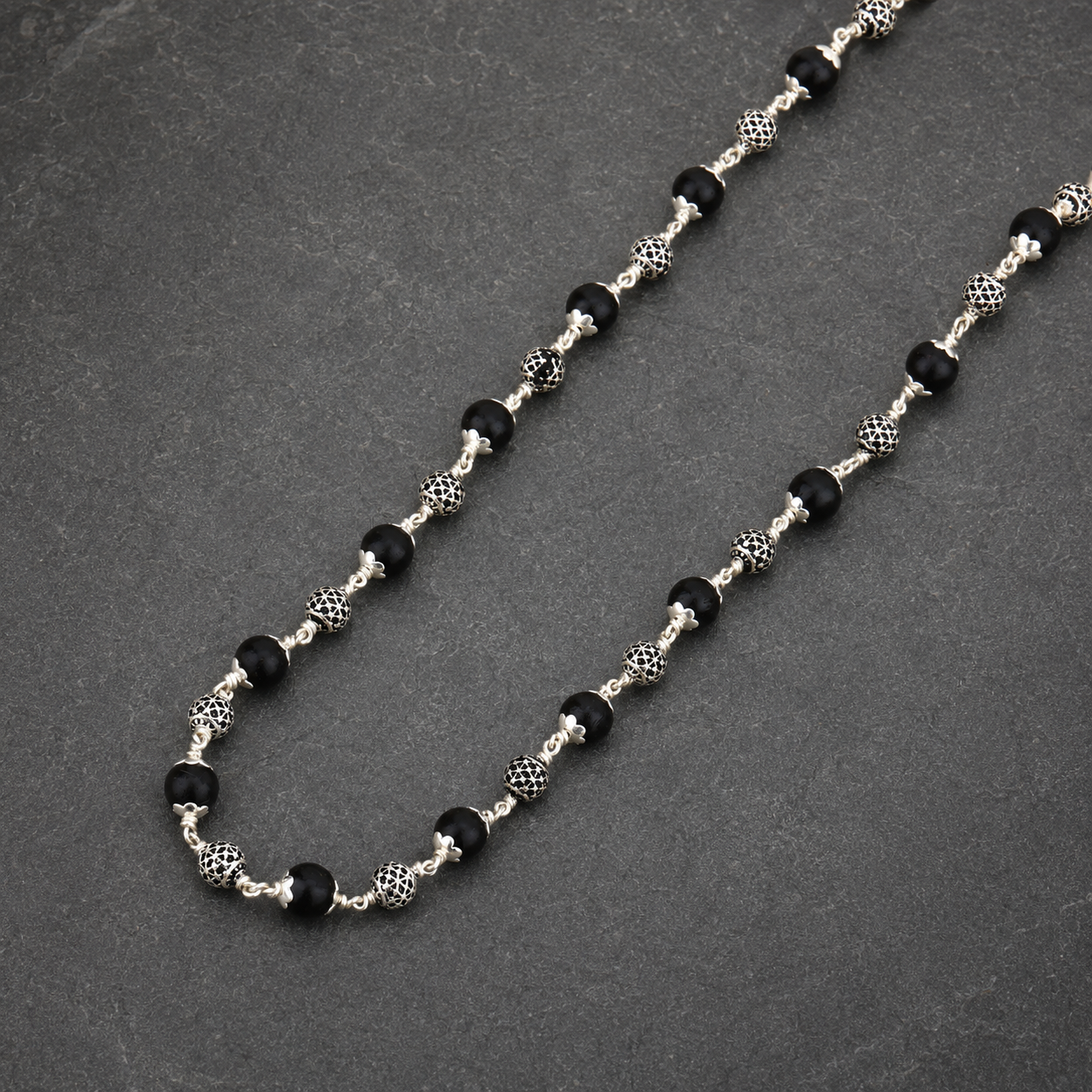 Karungali wood and polished round silver bead close-up