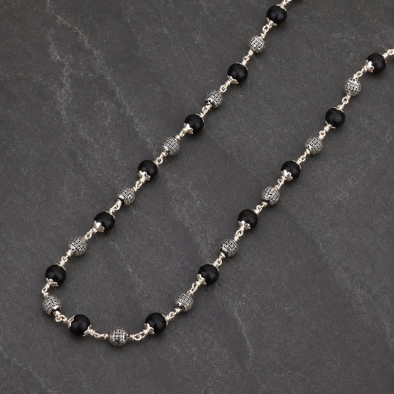Karungali wood and polished silver sphere close-up