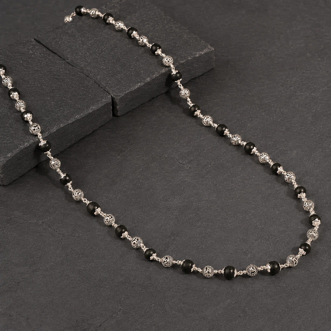 Karungali wood and silver Shiva mantra bead close-up
