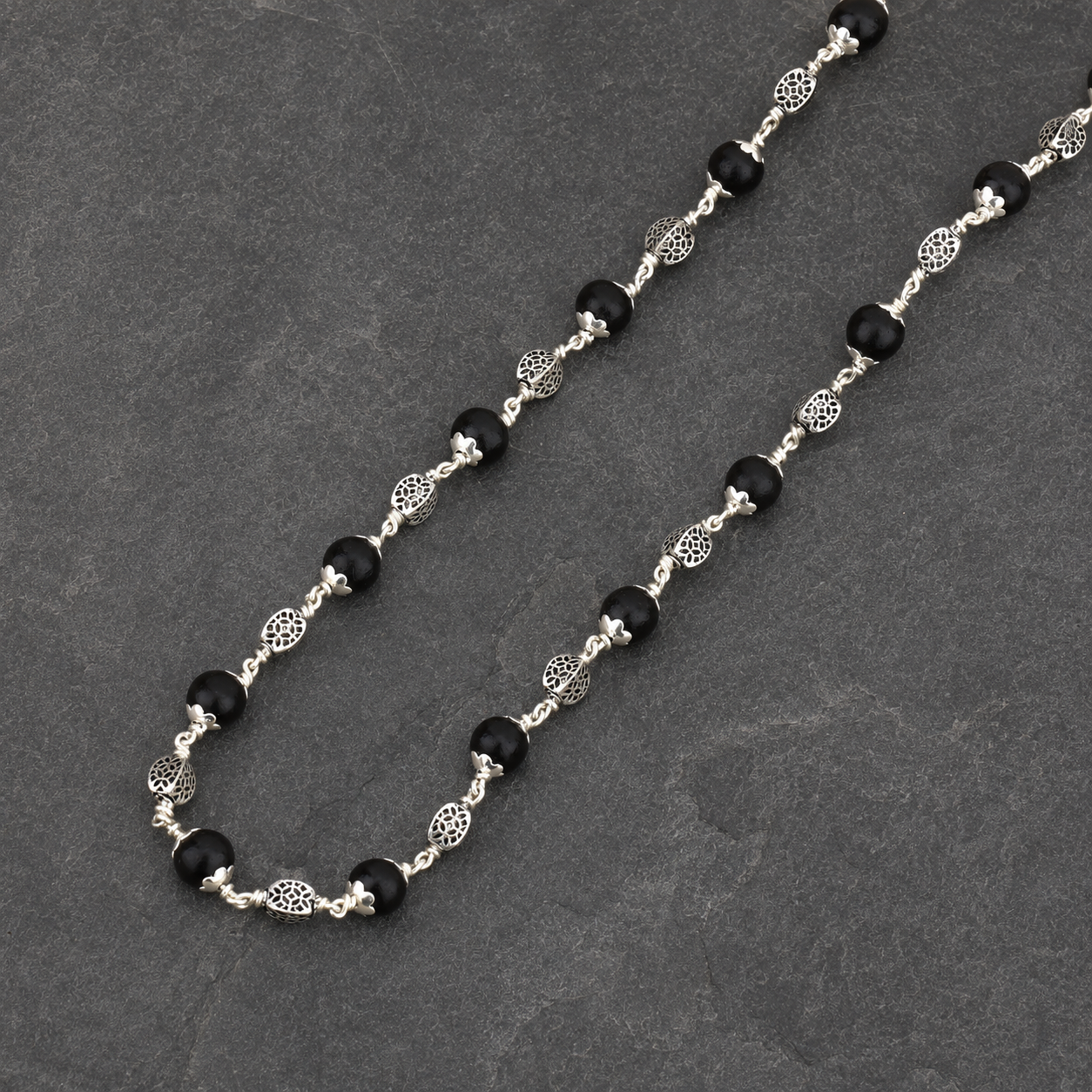Karungali wood and smooth silver oval bead close-up