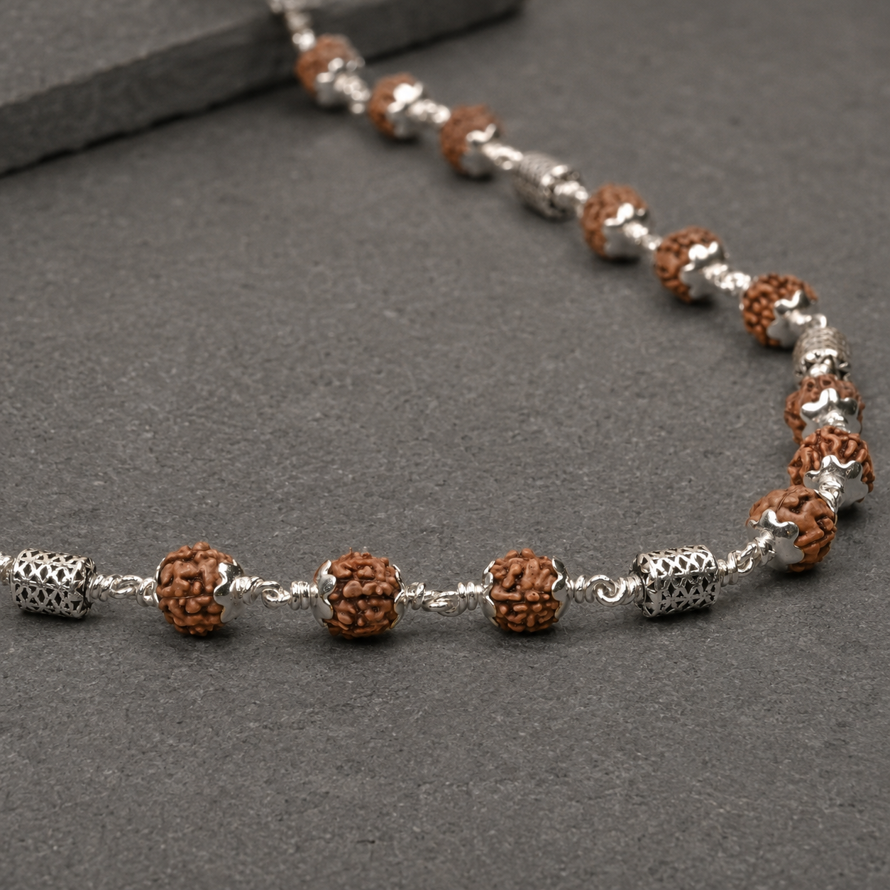 Natural Rudraksha and oval filigree silver bead close-up